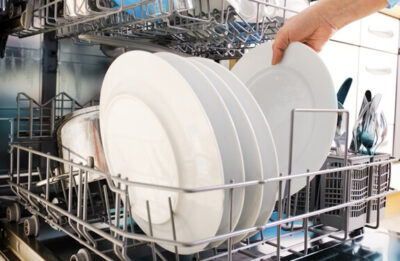 Appliance technician repairing a dishwasher